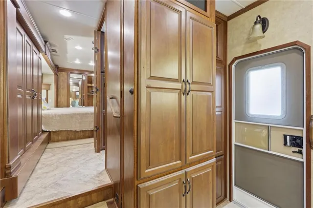 a view of a hallway with stainless steel appliances granite countertop cabinets and a window