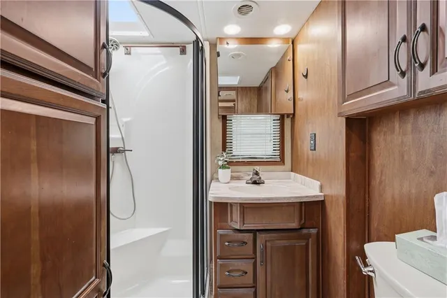 a bathroom with a sink a toilet and shower