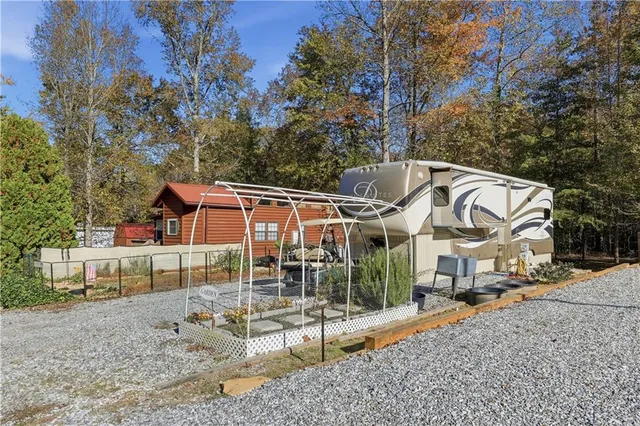 a view of a white house with a yard and sitting area