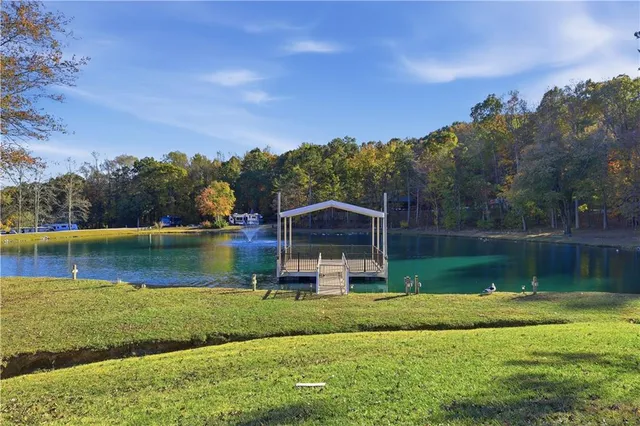 a view of a lake with a yard and large trees