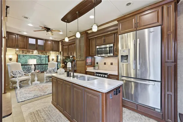 a kitchen with stainless steel appliances granite countertop a refrigerator a sink and a stove