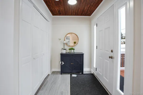 a view of a hallway to a house with wooden floor