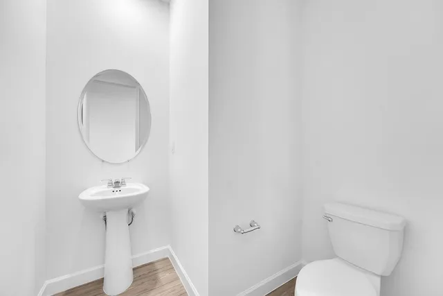 a bathroom with a toilet sink and a mirror
