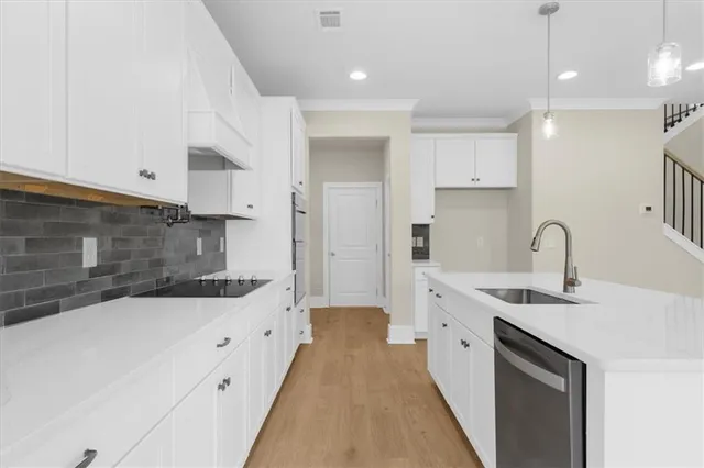a kitchen with granite countertop a sink a stove and cabinets