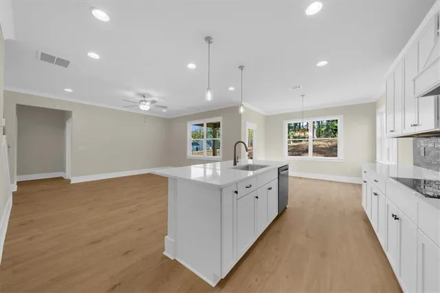 a large kitchen with stainless steel appliances granite countertop a large counter top and a window