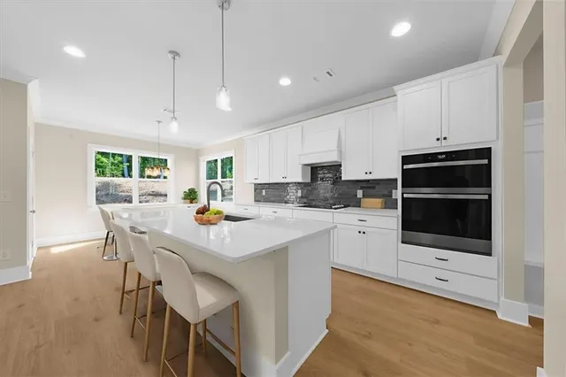 a kitchen with a dining table chairs and white cabinets