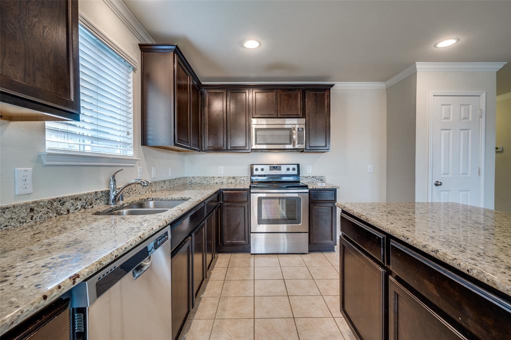 1420 Rivers Creek Lane Little Elm, TX 75068 - Photo 9 of 25 a kitchen with stainless steel appliances granite countertop a sink stove and refrigerator
