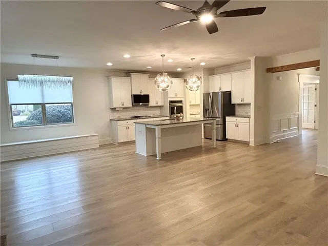 a view of kitchen with refrigerator stove and wooden floor