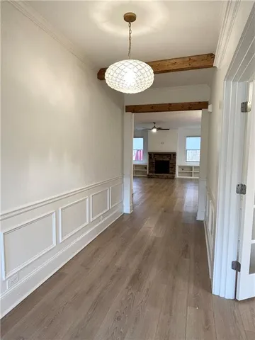 a view of a room with wooden floor fireplace and window