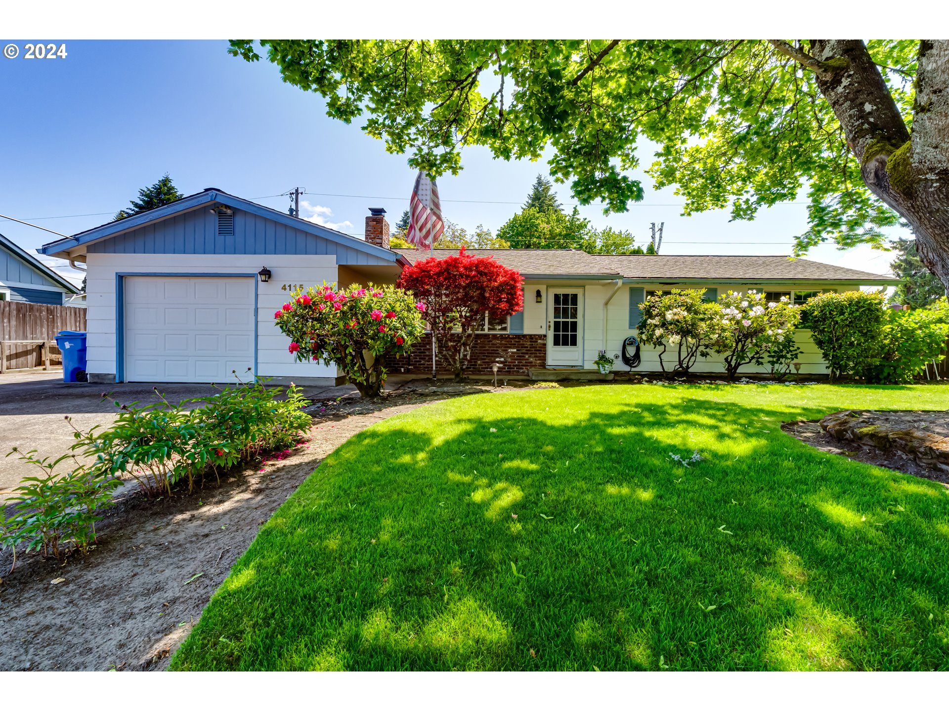 a front view of a house with a garden and yard