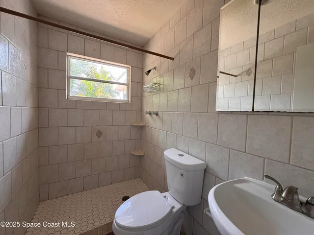 a white toilet sitting next to a bathroom sink