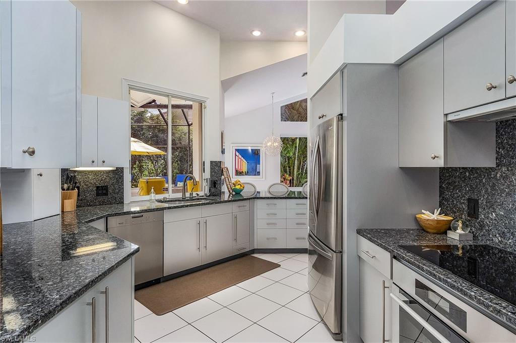 720 Turkey Oak Lane Naples, FL 34108 - Photo 12 of 31 a kitchen with stainless steel appliances granite countertop a sink stove and refrigerator