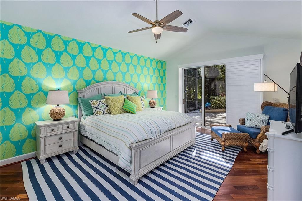 720 Turkey Oak Lane Naples, FL 34108 - Photo 14 of 31 a bedroom with a bed and a chandelier