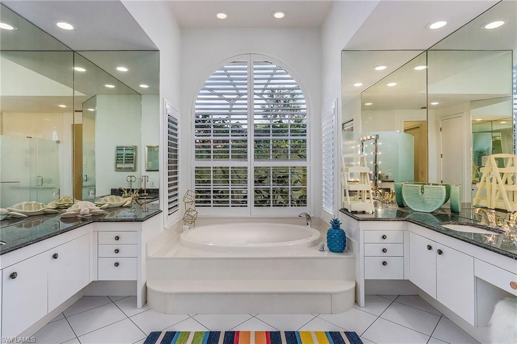 720 Turkey Oak Lane Naples, FL 34108 - Photo 18 of 31 a spacious bathroom with a tub sink and mirror