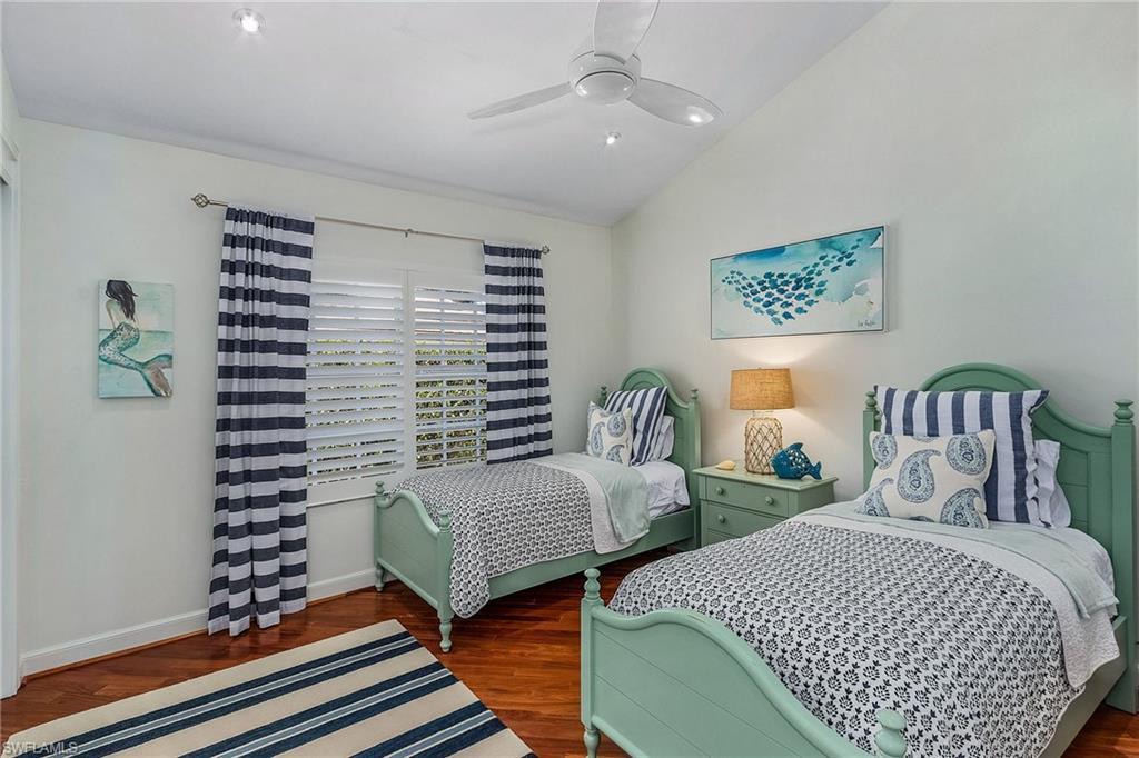 720 Turkey Oak Lane Naples, FL 34108 - Photo 20 of 31 a bedroom with two beds and a potted plant
