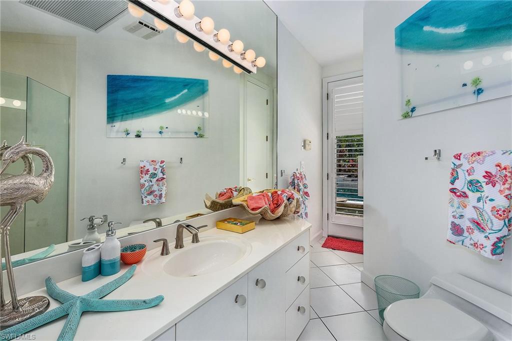 720 Turkey Oak Lane Naples, FL 34108 - Photo 23 of 31 a bathroom with a sink mirror vanity and toilet