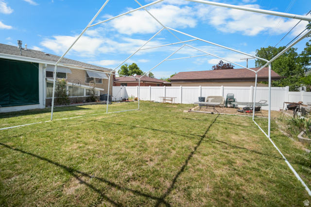 3233 Jean Street Magna, UT 84044 - Photo 2 of 33 Expansive backyard featuring a green lawn and a white privacy fence