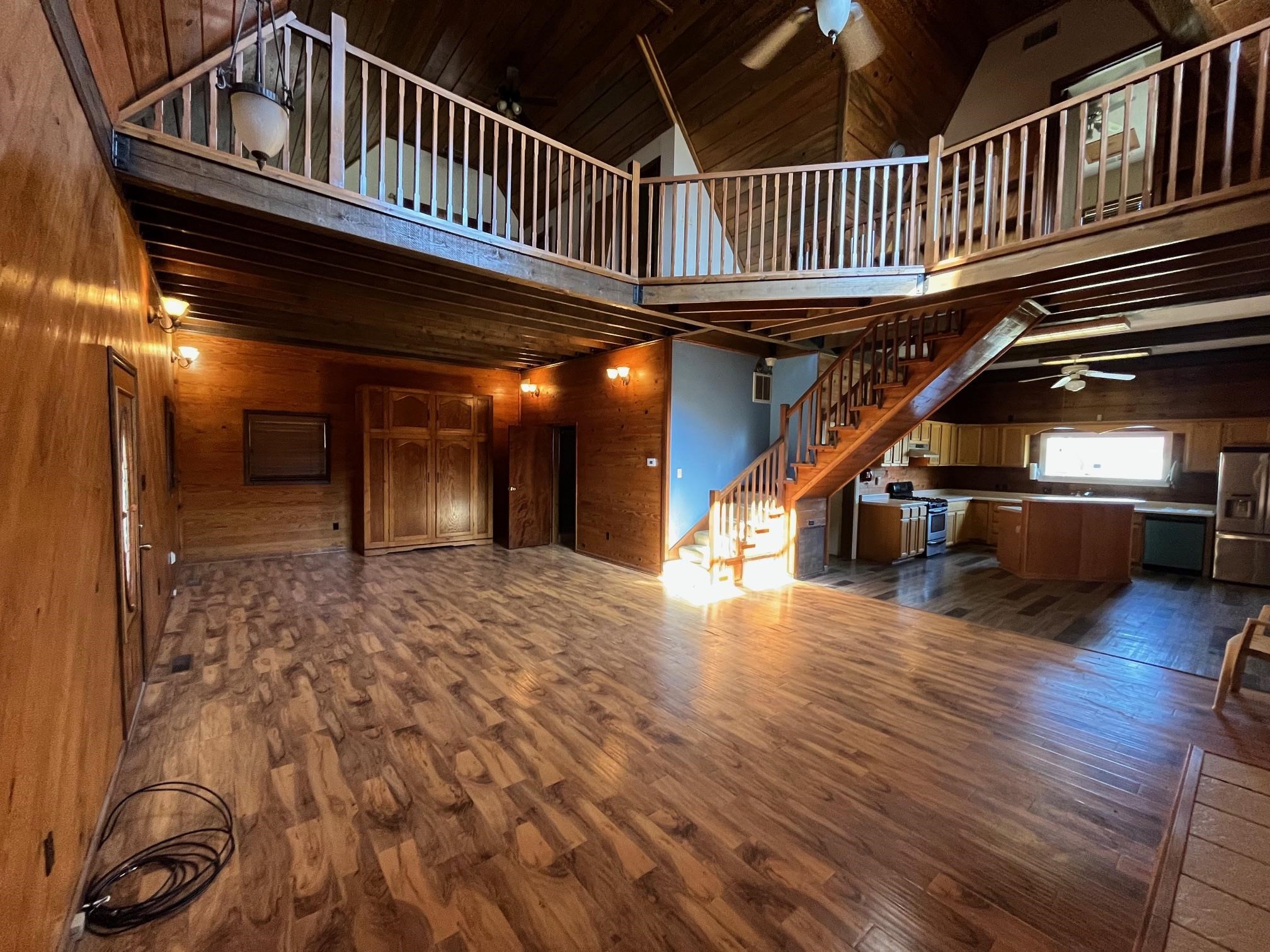 4161 Lucy Road Millington, TN 38053 - Photo 15 of 24 Unfurnished living room featuring ceiling fan, wooden walls, dark wood-type flooring, and a vaulted wood ceiling