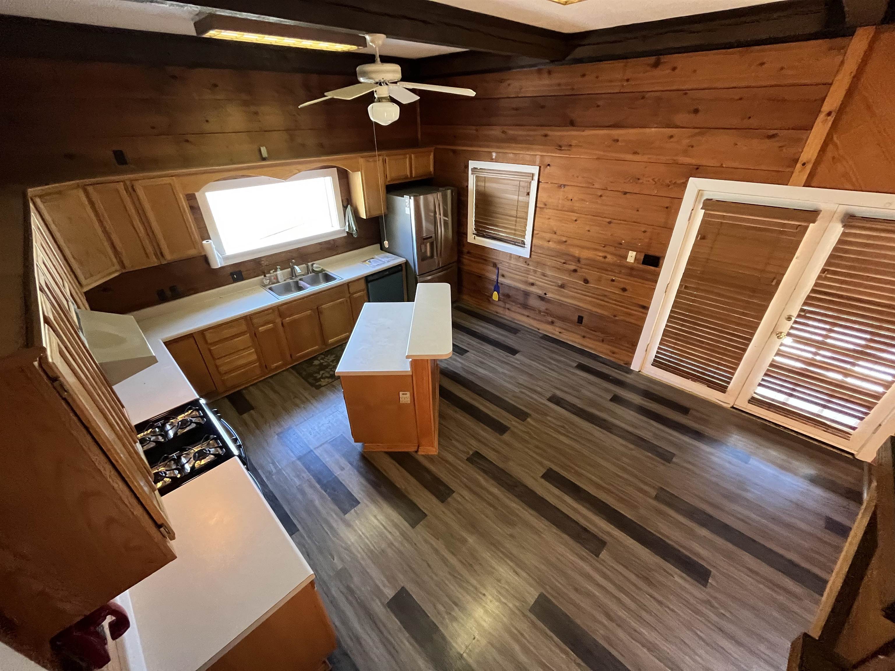 4161 Lucy Road Millington, TN 38053 - Photo 17 of 24 Kitchen with light countertops, wooden walls, a ceiling fan, beamed ceiling, and dark wood finished floors