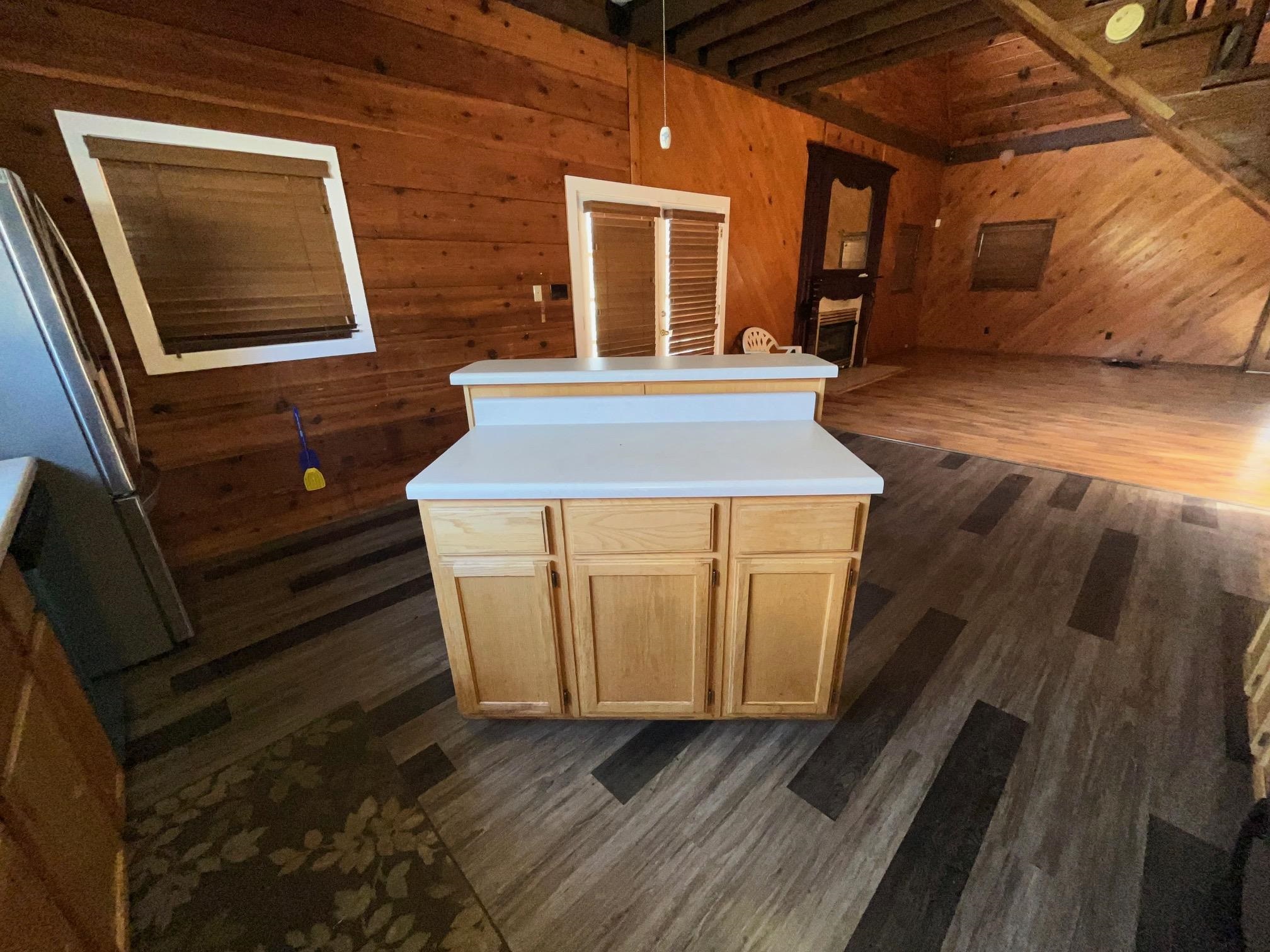 4161 Lucy Road Millington, TN 38053 - Photo 9 of 24 Kitchen with wood walls, light countertops, freestanding refrigerator, a center island, and light wood finish cabinets