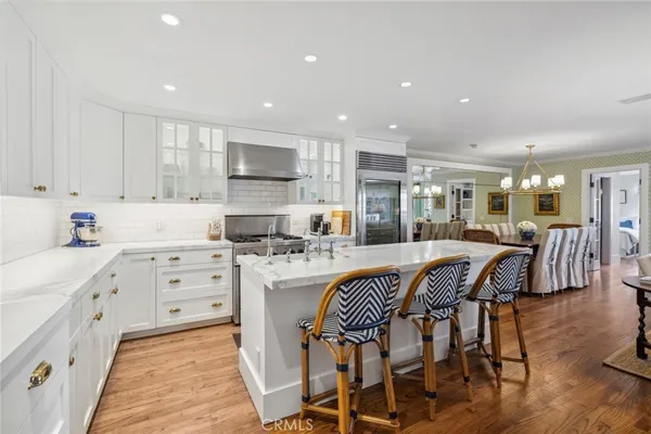 a large kitchen with kitchen island granite countertop lots of white cabinets appliances and furniture
