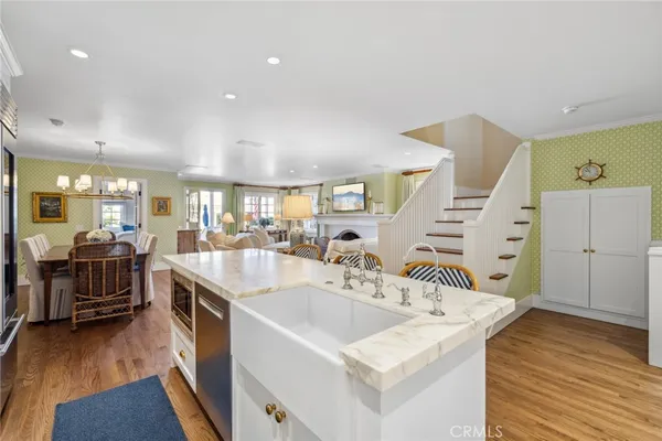 a kitchen with stainless steel appliances kitchen island granite countertop a sink and wooden floors