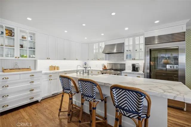 a large kitchen with kitchen island a island a stove a cabinets a sink and a island