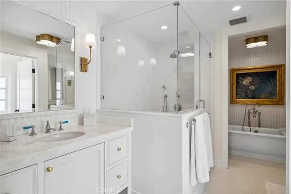 a bathroom with a tub sink and mirror
