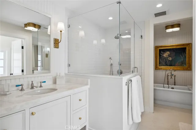 a bathroom with a tub sink and mirror