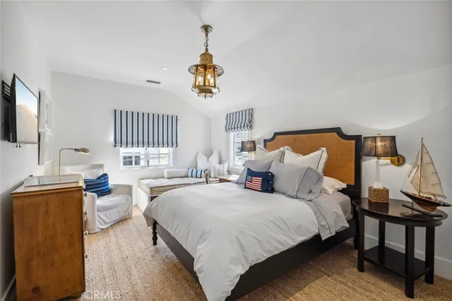 a spacious bedroom with a bed a window and dresser