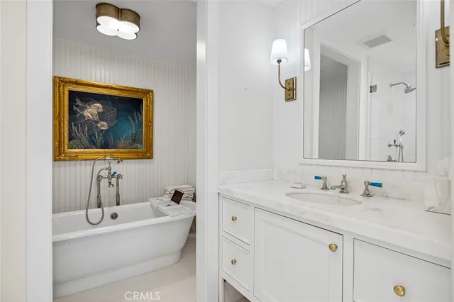 a bathroom with a tub a sink and mirror