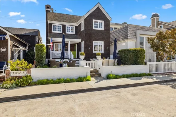 a front view of a house with a yard and potted plants