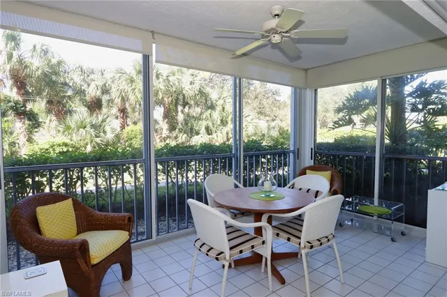 a dining room with furniture a large window and a garden