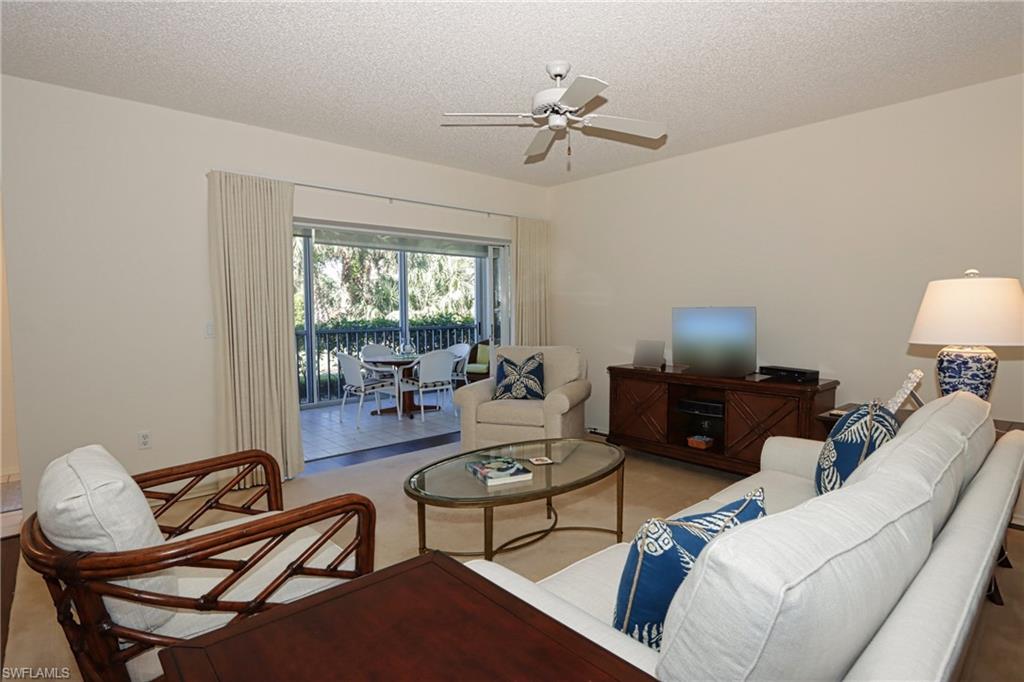 765 Willowbrook Drive, Unit 1503 Naples, FL 34108 - Photo 3 of 19 a living room with furniture and a flat screen tv