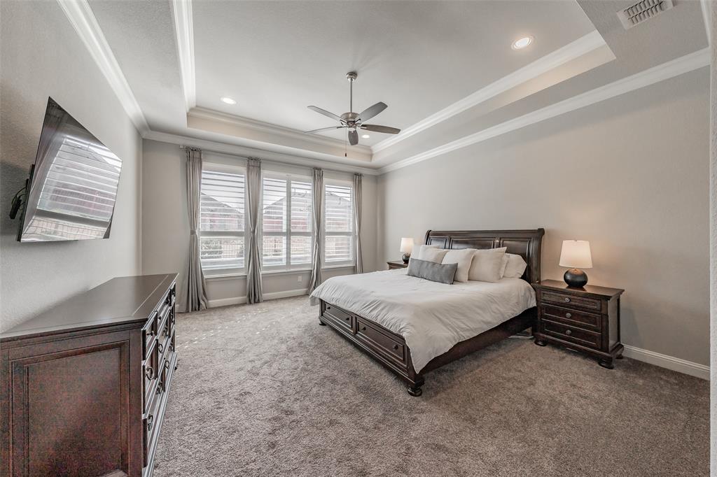 11609 Little Elm Creek Road Flower Mound, TX 76226 - Photo 14 of 40 a spacious bedroom with a bed a chandelier and a window