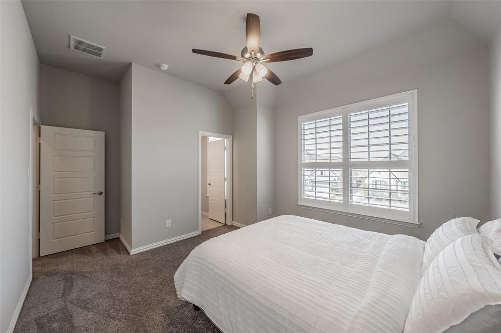 11609 Little Elm Creek Road Flower Mound, TX 76226 - Photo 22 of 40 a bedroom with a large bed and a chandelier