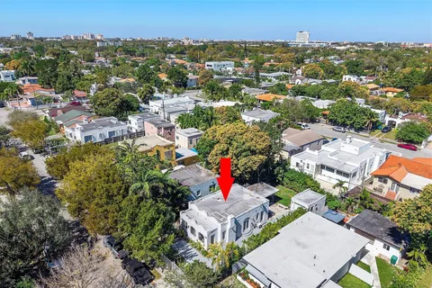 an aerial view of residential houses with outdoor space and trees
