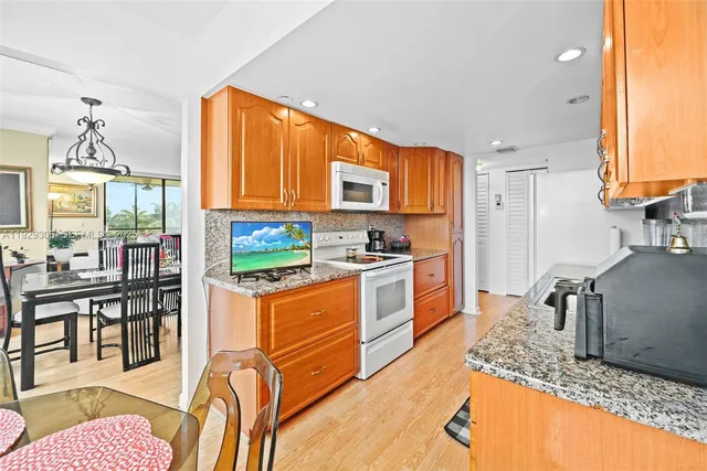 a kitchen with stainless steel appliances granite countertop a sink a refrigerator and cabinets