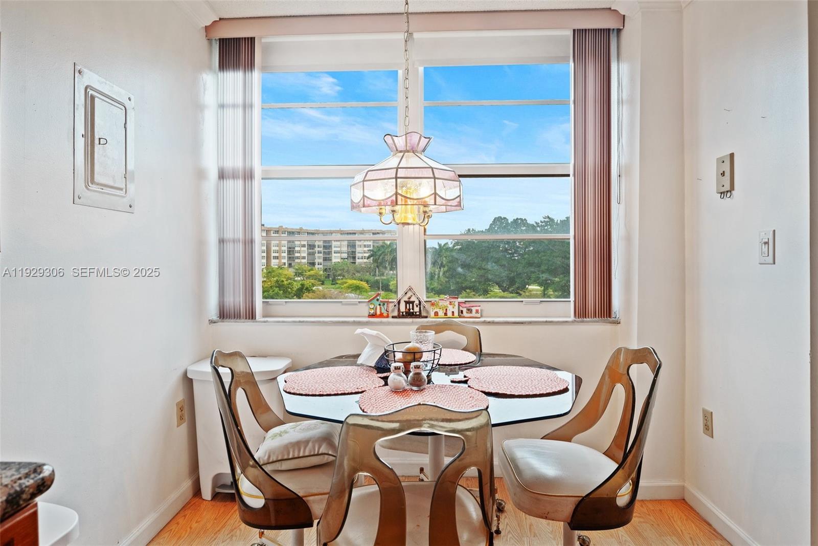 900 St Charles Place, Unit 419 Pembroke Pines, FL 33026 - Photo 16 of 27 a dining room with furniture a chandelier and wooden floor