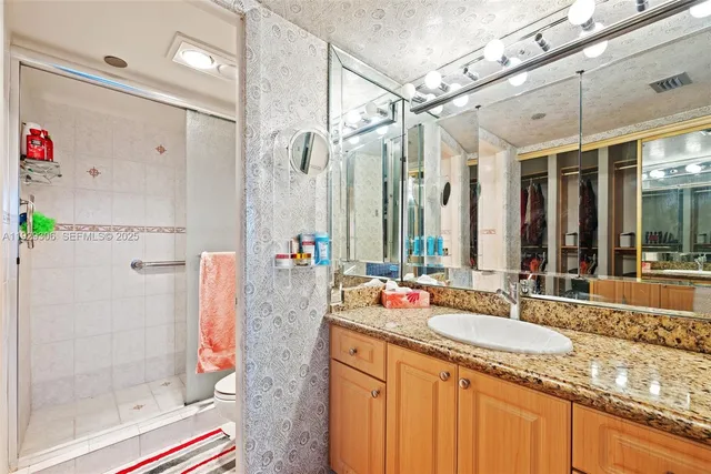 a bathroom with a granite countertop shower and a sink