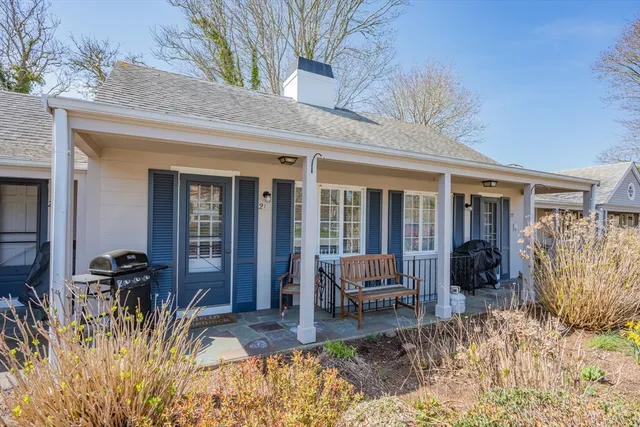 a backyard of a house with barbeque oven table and chairs