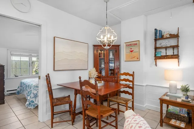 a living room with furniture a dining table and a chandelier