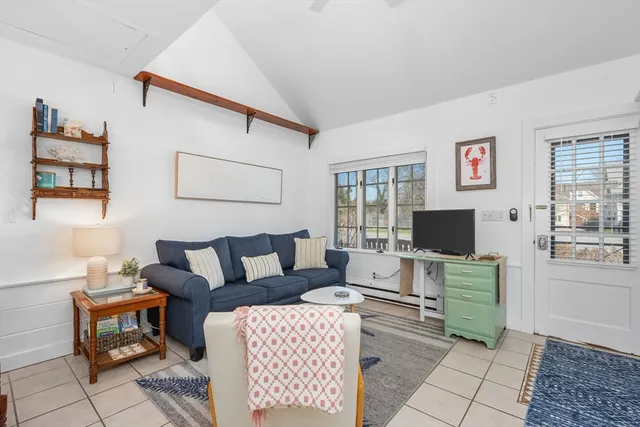 a living room with furniture a flat screen tv and a window
