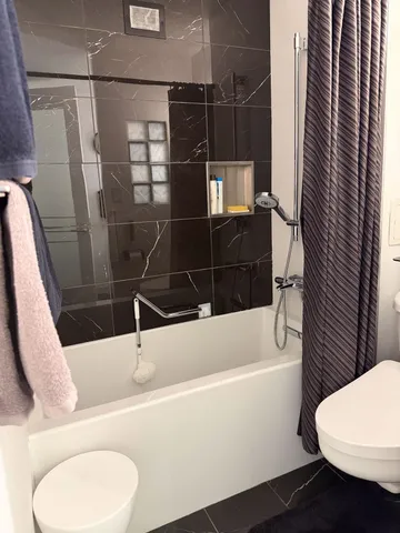 a bathroom with a toilet and a shower