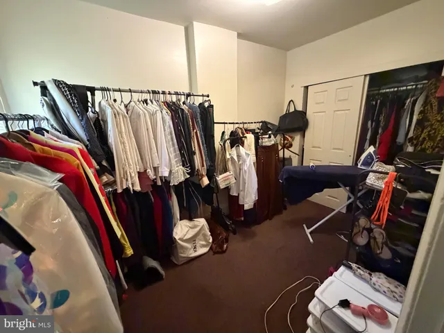 a view of walk in closet with clothes and shoes