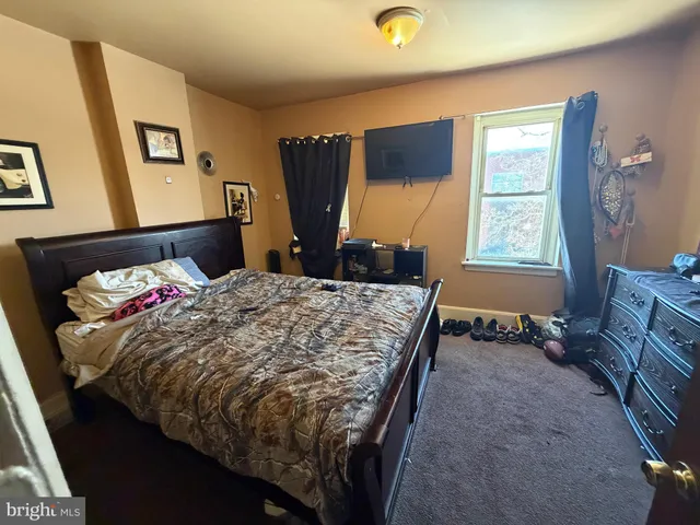a bed sitting in a bedroom next to a window