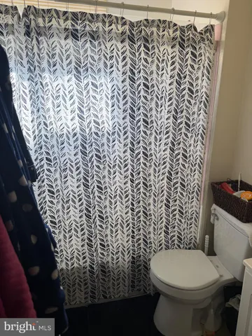 a bathroom with a toilet and a shower curtain