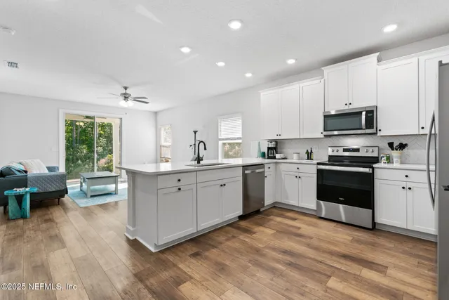 a kitchen with a refrigerator sink and white cabinets