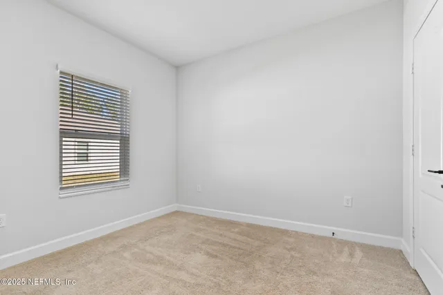 a view of an empty room with a cabinet and mirror