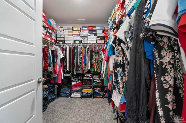 a view of walk in closet with clothes